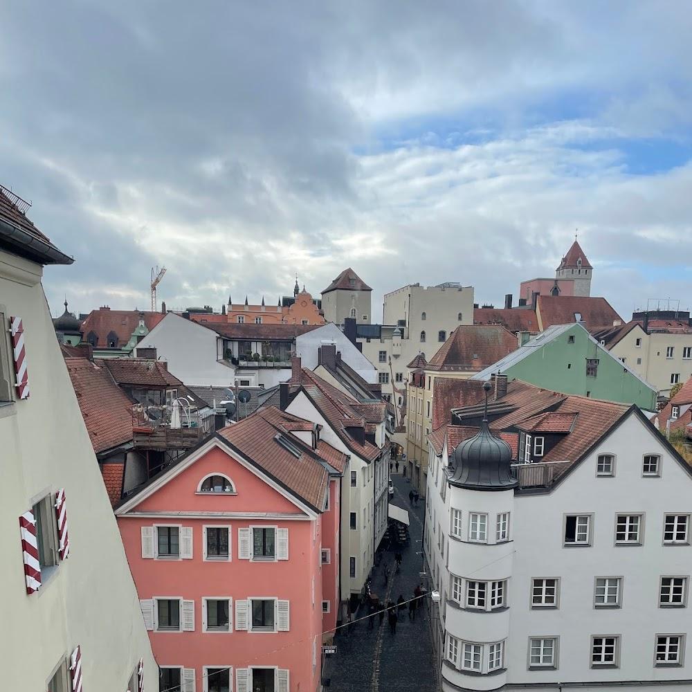 European city street scene with buildings, cobblestones and people.